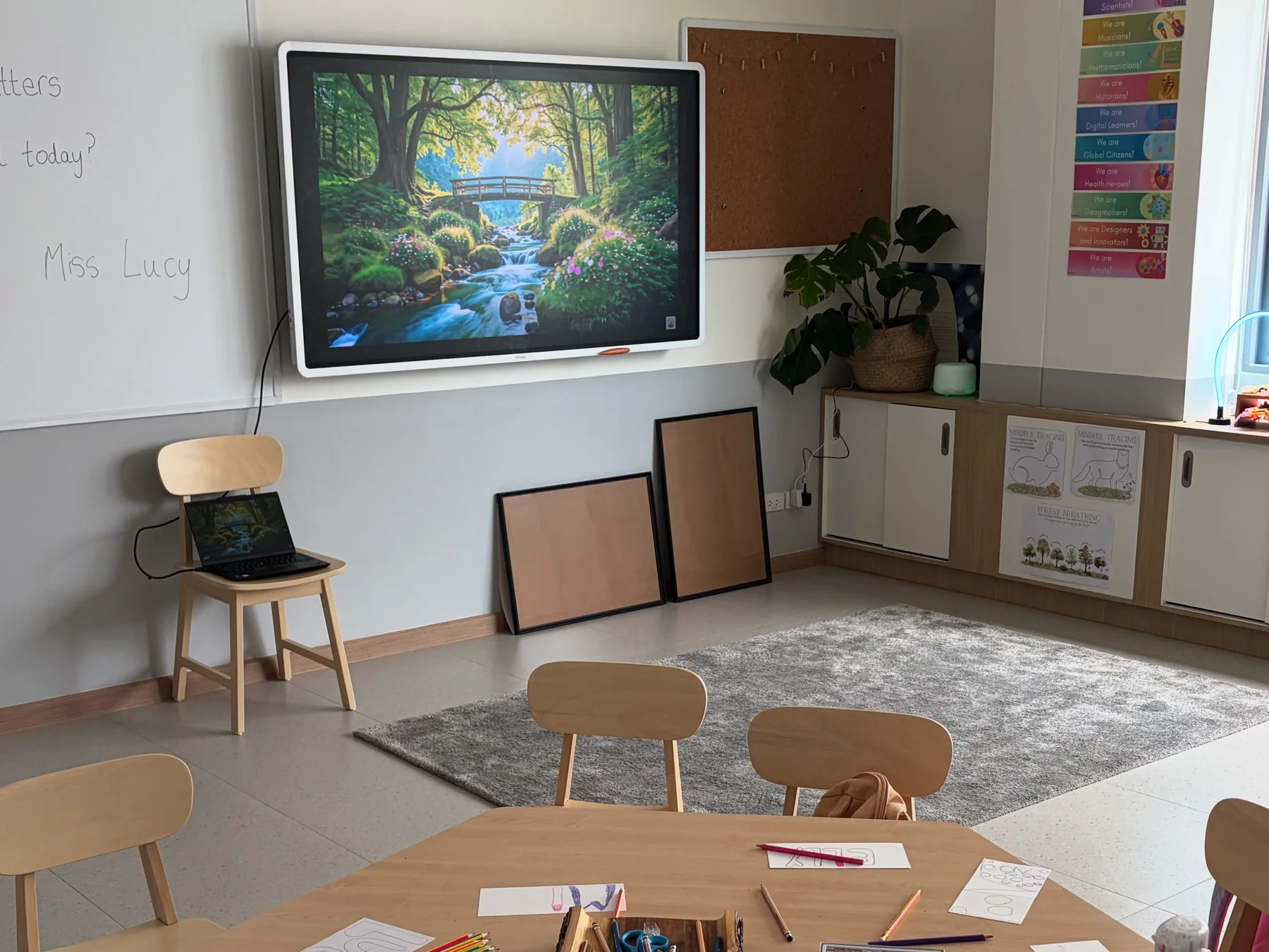 An EtonHouse classroom: a ClassIn Board on the wall, a rug in front of it and a table set with coloured pencils and drawings.