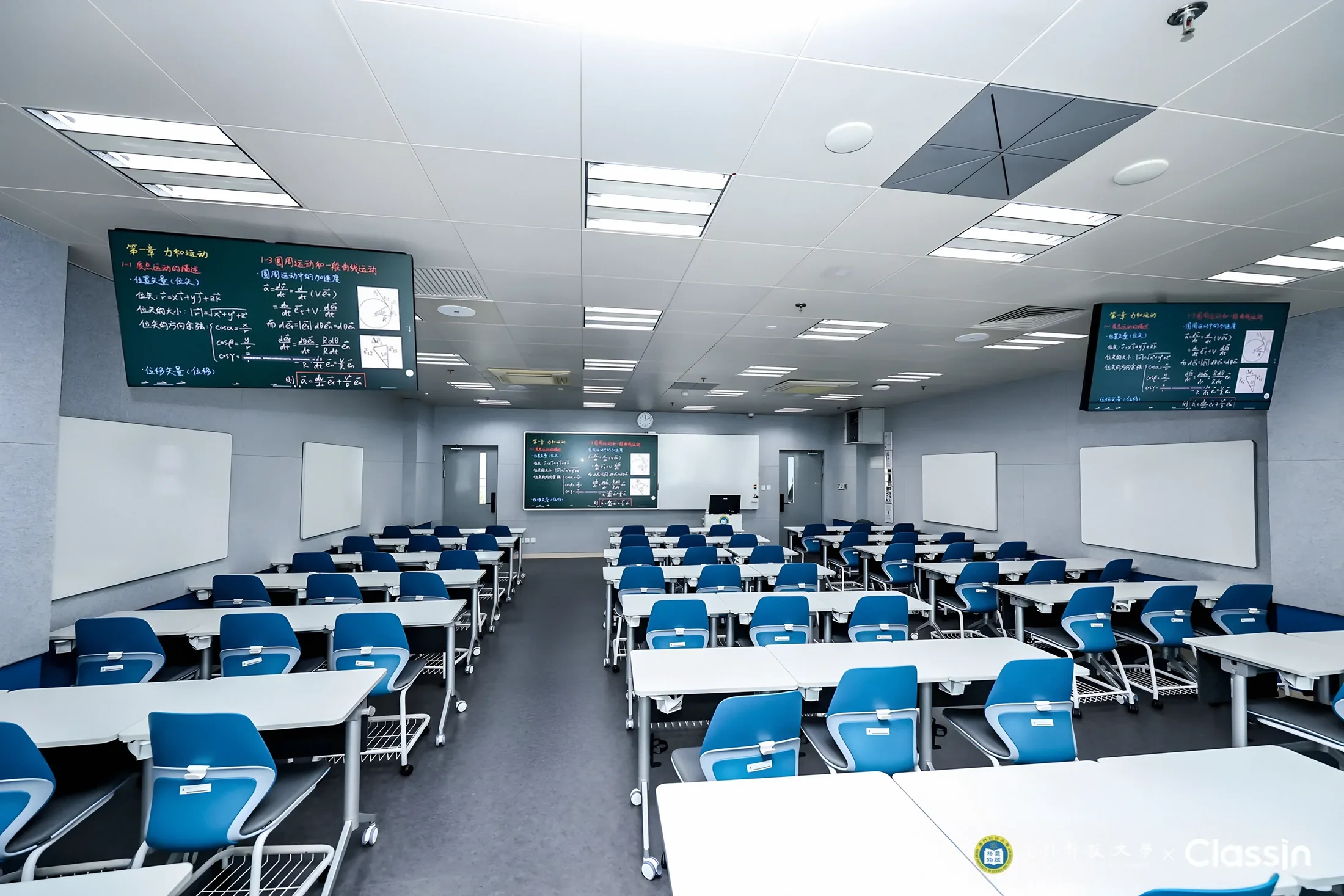 A row classroom in the MUST Future Learning Centre: blue chairs face the teaching screen at the front, with more screens along the walls.