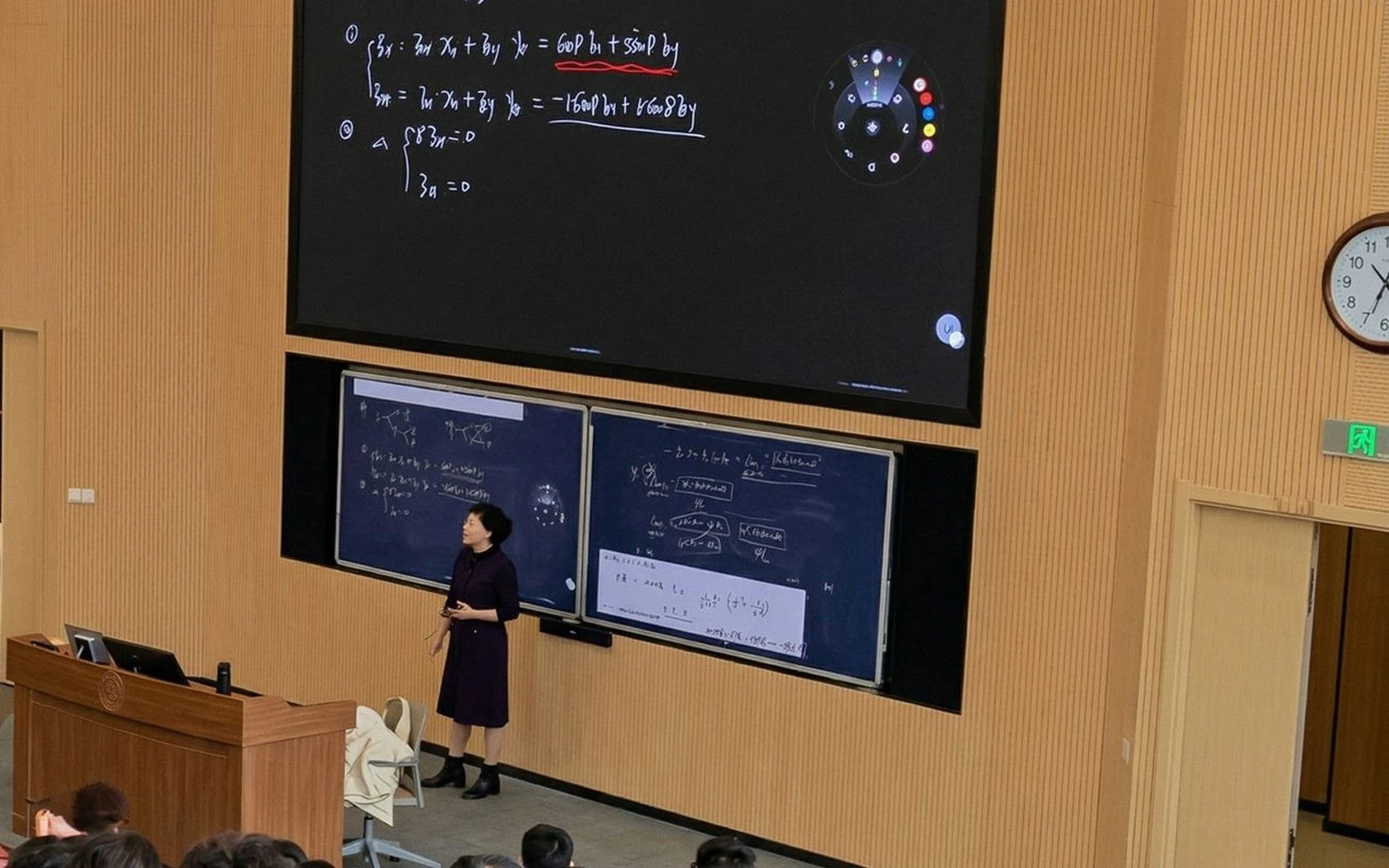 A large lecture hall at Shanghai Jiao Tong University, with interactive screens showing a lecturer’s mathematical working.