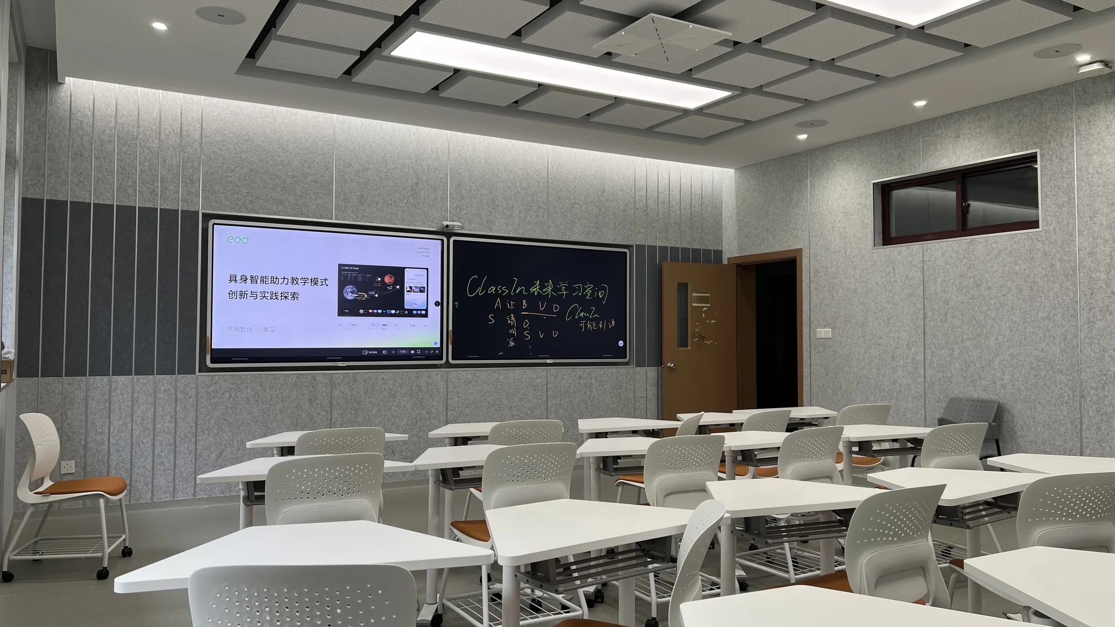 A Tongji University classroom with two screens at the front, one with slides and one with handwriting, and rows of white desks.