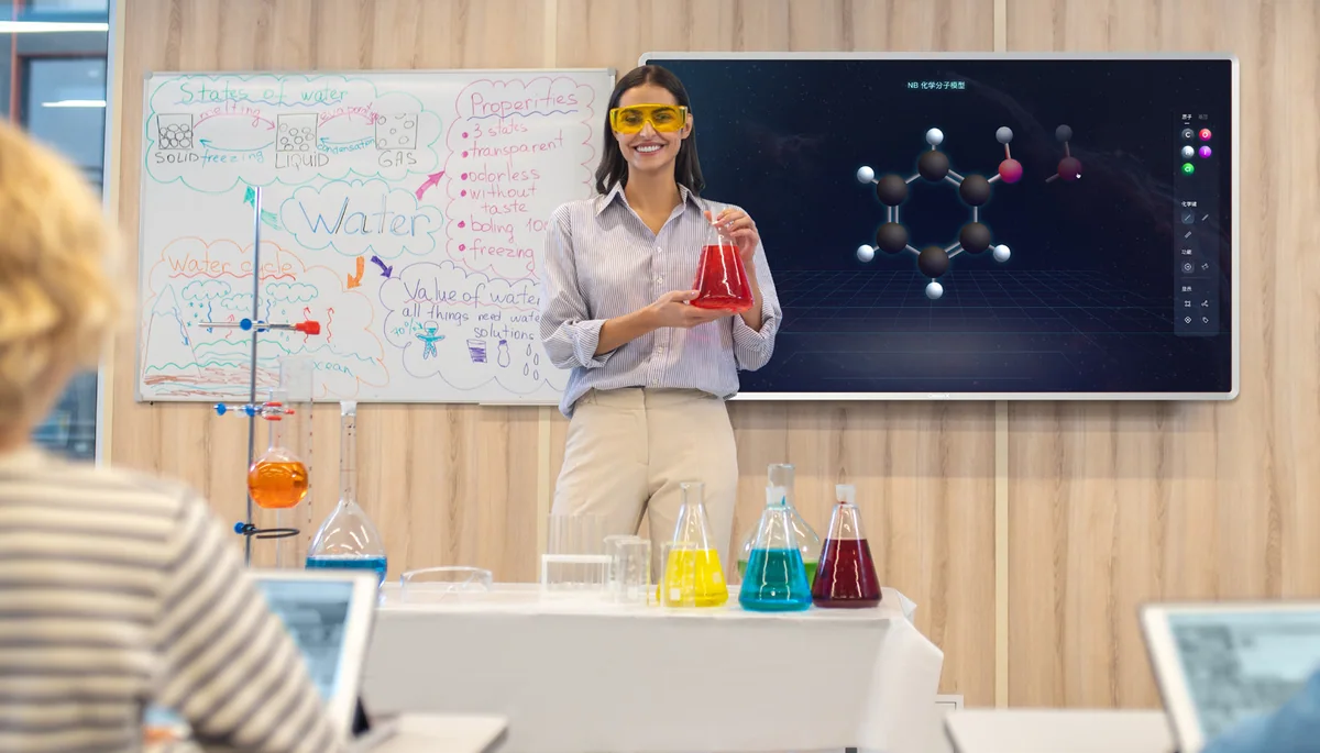 A science teacher in safety glasses holds a flask beside a ClassIn Board showing a 3D molecule.