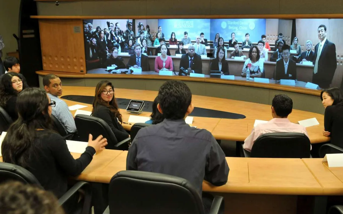 A seminar round a conference table, with remote participants on the video wall.